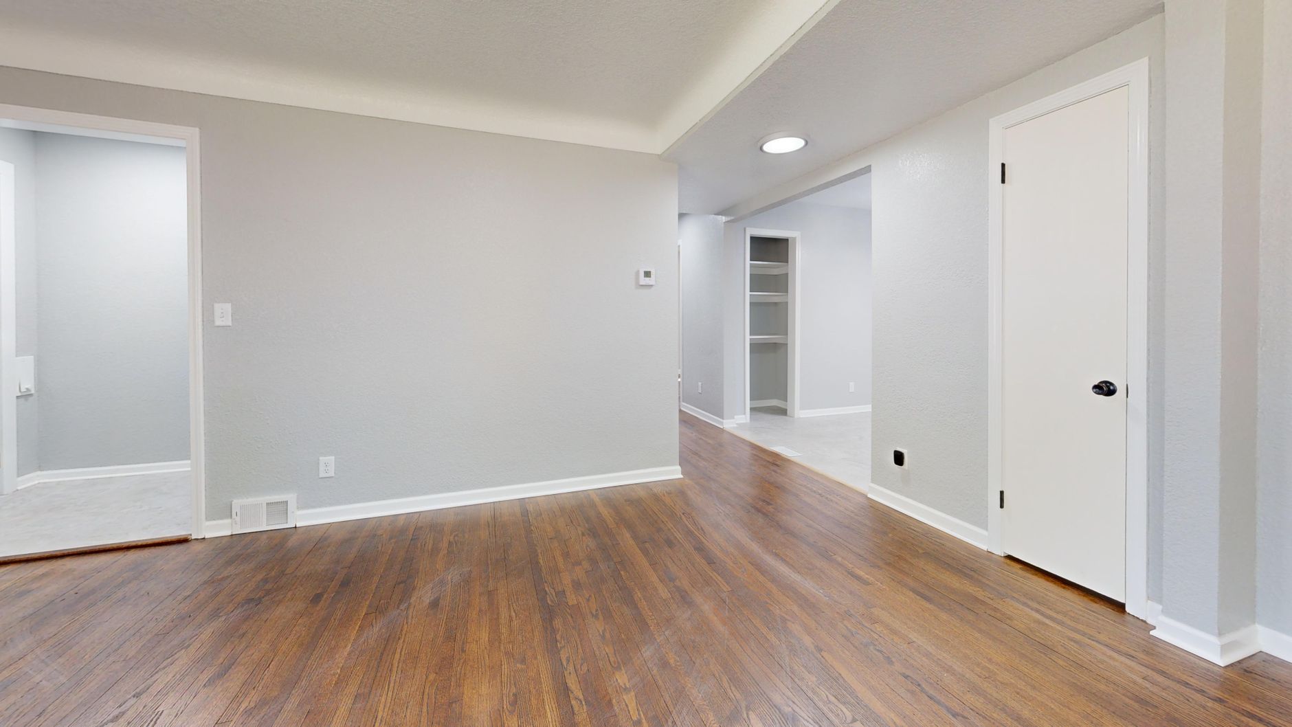 Wide plank wood flooring in an empty room with natural light
