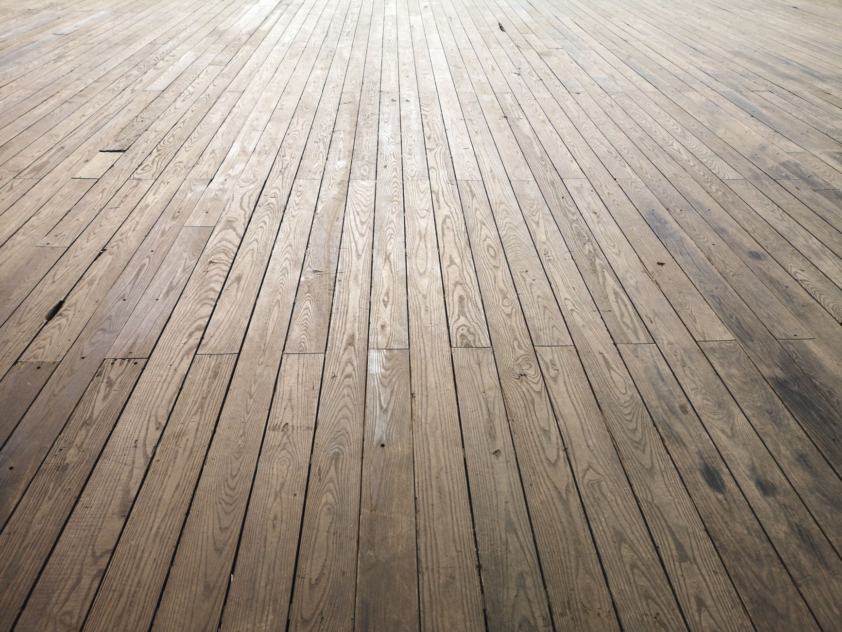 Aged hardwood floor boards showing grain and wear before refinishing