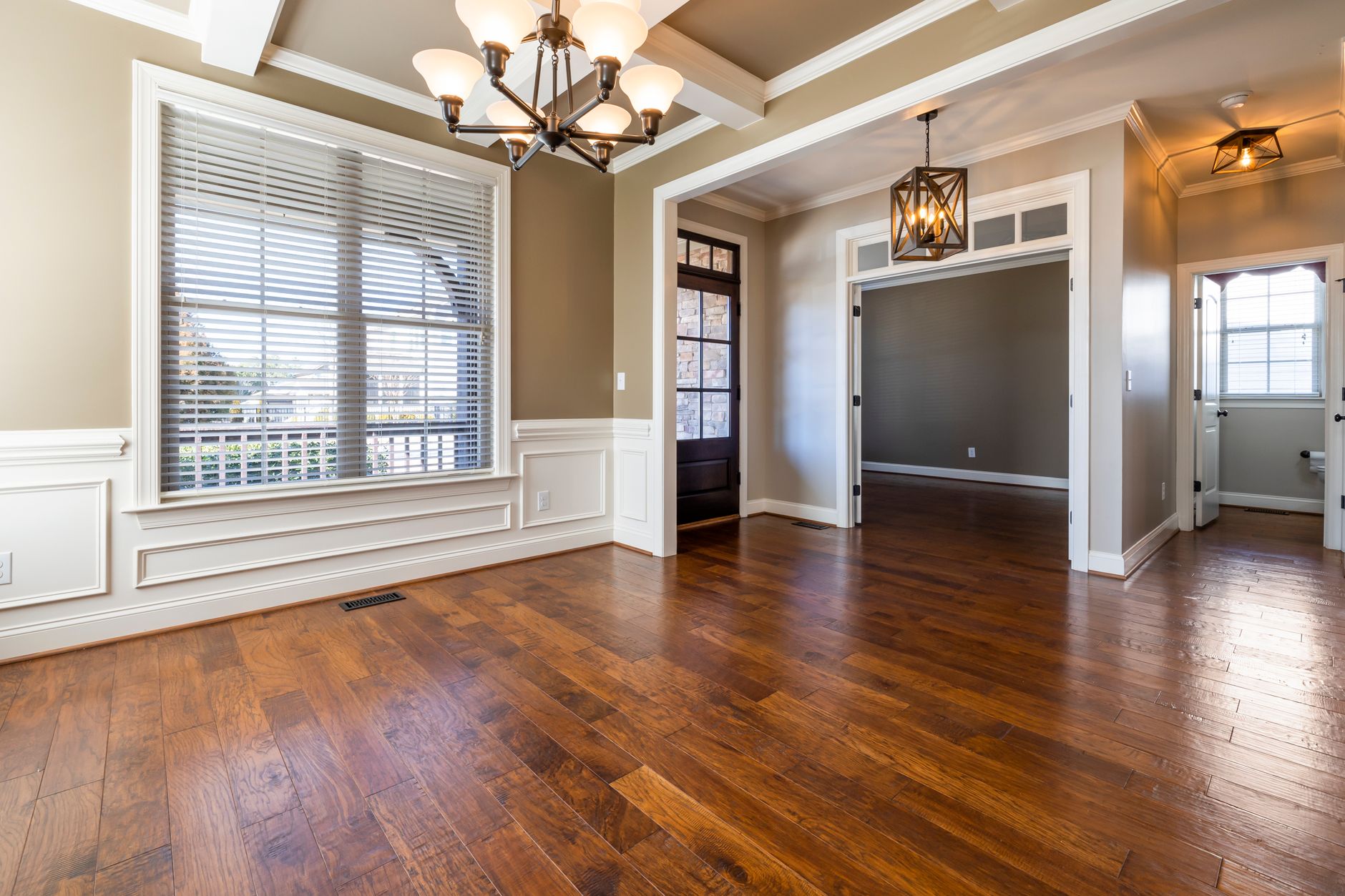 Elegant room with wooden flooring, chandelier, and natural lighting