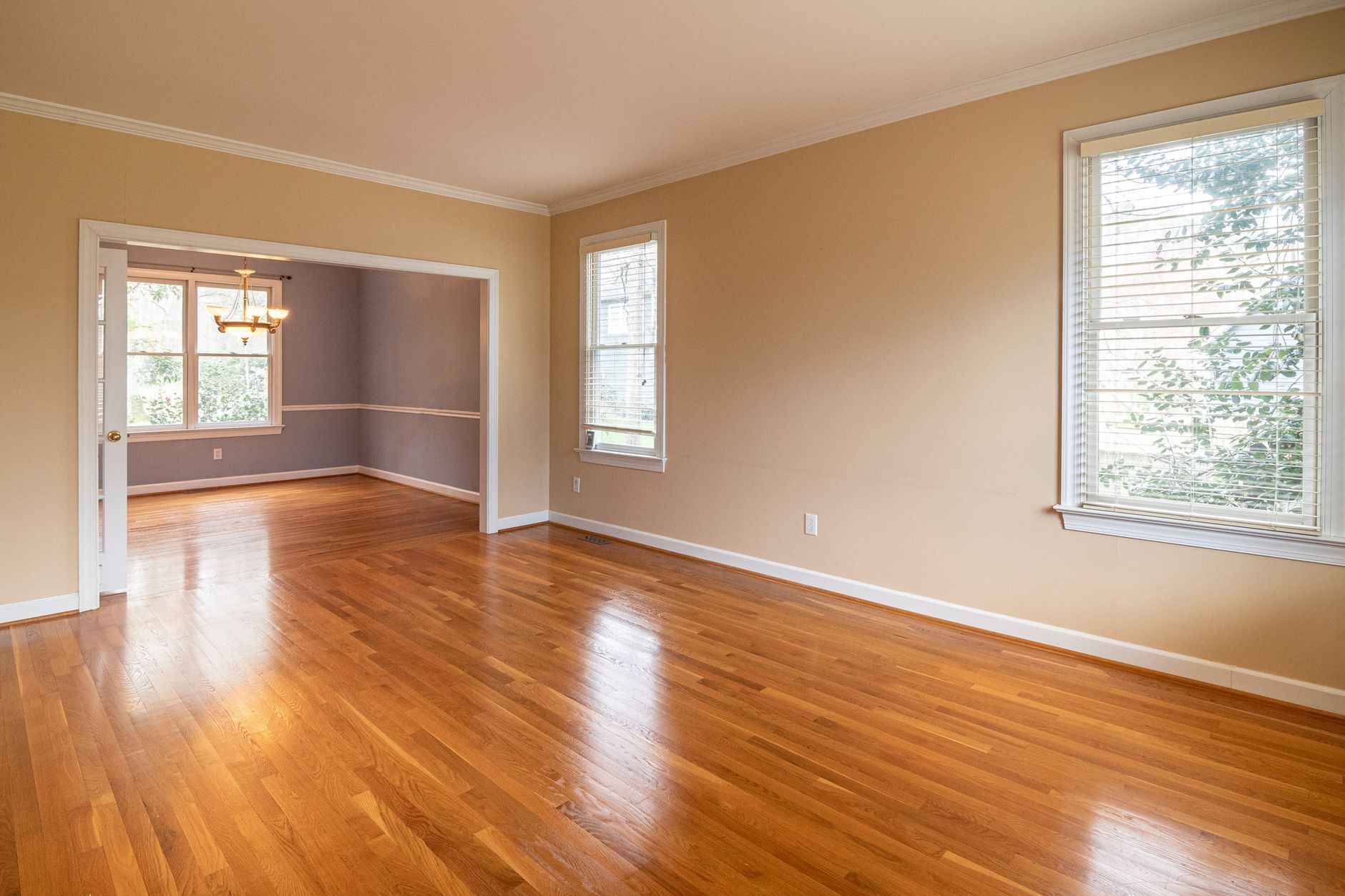 Bright empty room with wooden floors and large windows